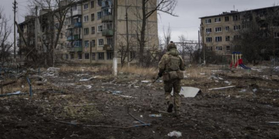 Украински военнослужещ бяга, за да заеме позиция в жилищна сграда в град Вухледар, Украйна.