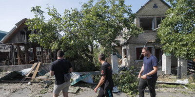 Трима мъже проверяват разрушените къщи в село близо до Киев